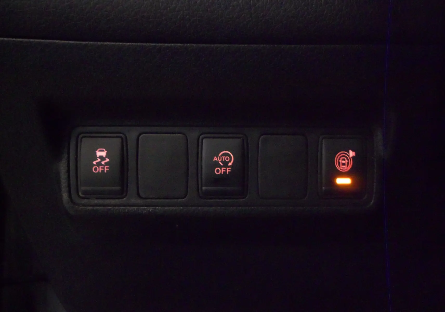 Panneau de commandes intérieures avec boutons d'assistance et verrouillage éclairés sur Nissan Pulsar gris Glacier 2019.