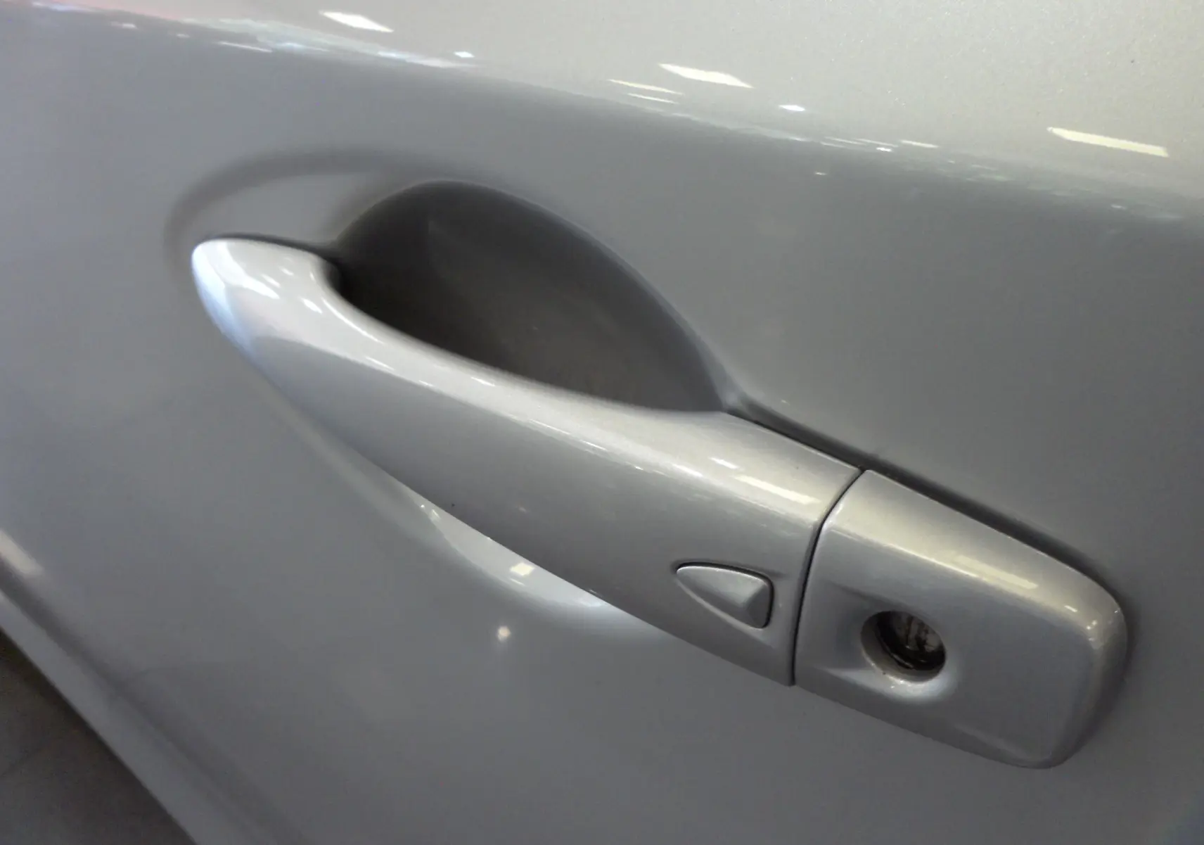 Poignée de porte gris glacier de la Nissan Pulsar 2019, vue rapprochée côté gauche avec serrure visible.