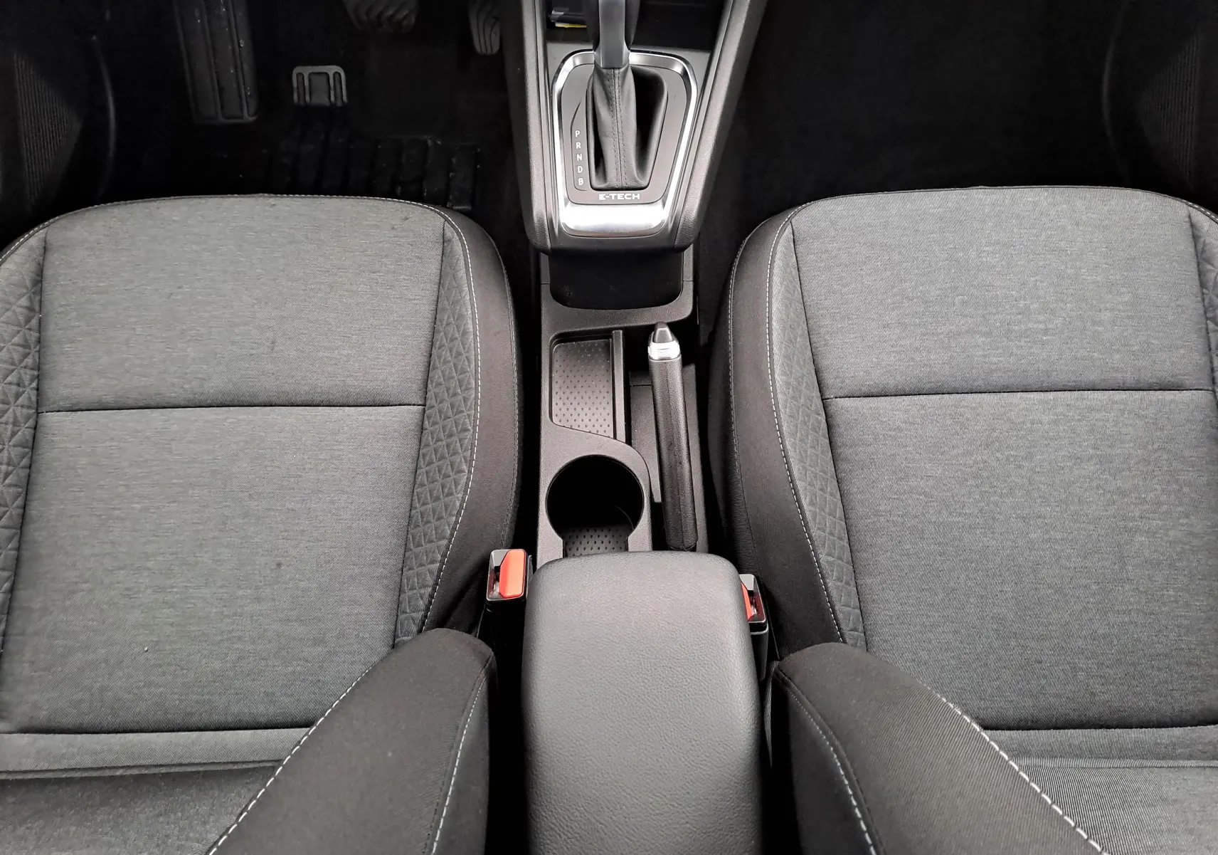 Vue plongeante sur les sièges avant gris tissu et la console centrale avec levier de vitesse automatique du Renault Captur 2022.