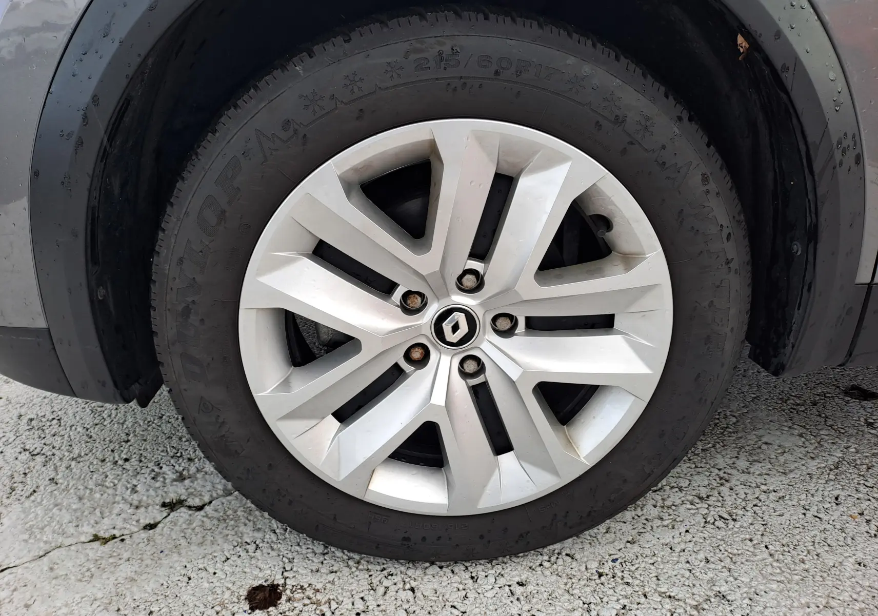 Gros plan sur la roue avant gauche du Renault Captur gris Cassiopée, jante alliage à design moderne.