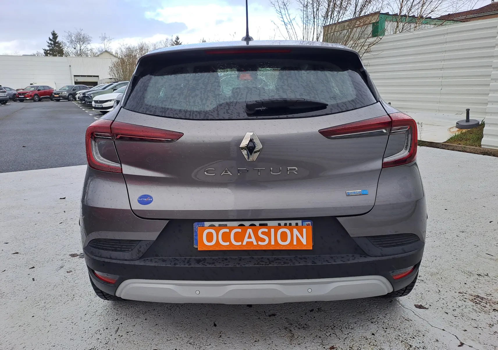 Vue arrière d'un Renault Captur gris cassiopée métal 2022 avec logo et plaque orange "OCCASION" visible.