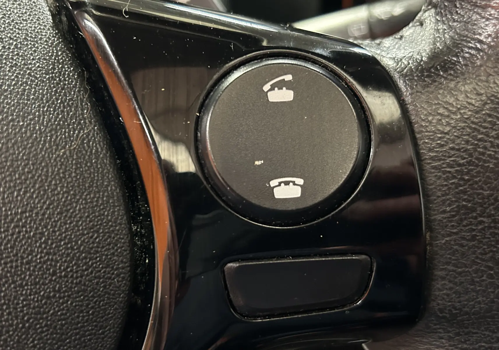 Gros plan sur les boutons de commande d’appel au volant noir de la Citroën C1 Airscape rouge de 2019.