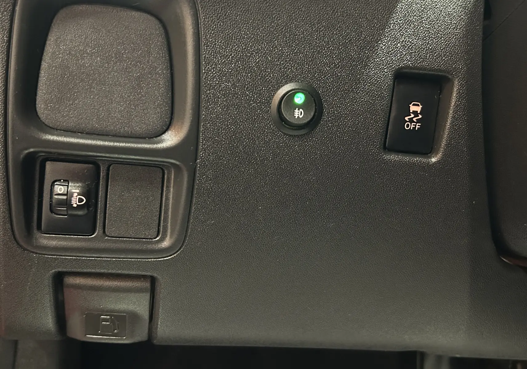 Vue rapprochée du tableau de bord noir de la Citroën C1 rouge, montrant les commandes d’éclairage et de stabilité.