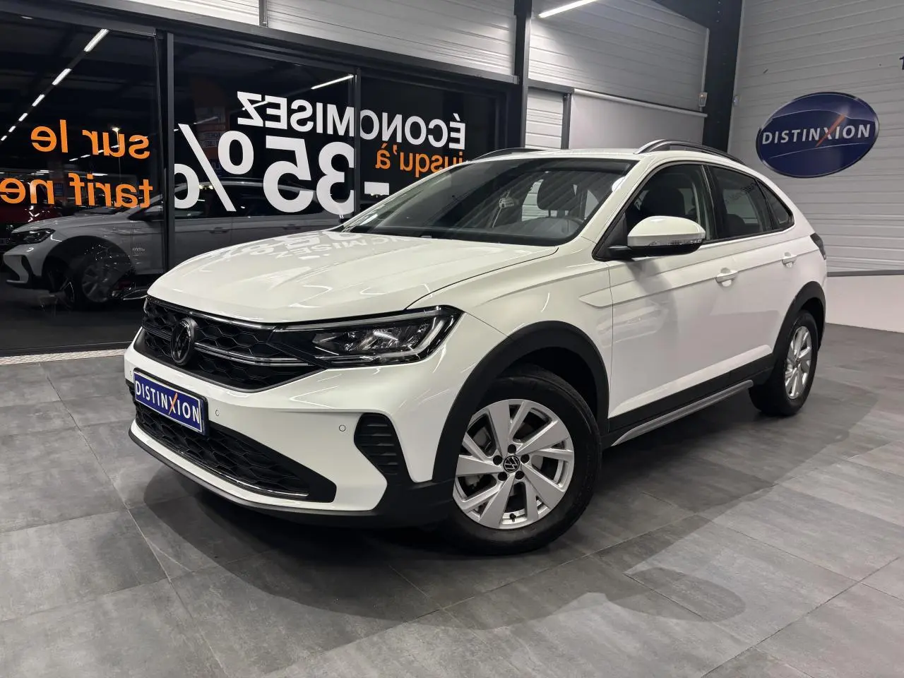 Volkswagen Taigo blanc en vue 3/4 avant droit, avec jantes alliage léger et calandre noire brillante.