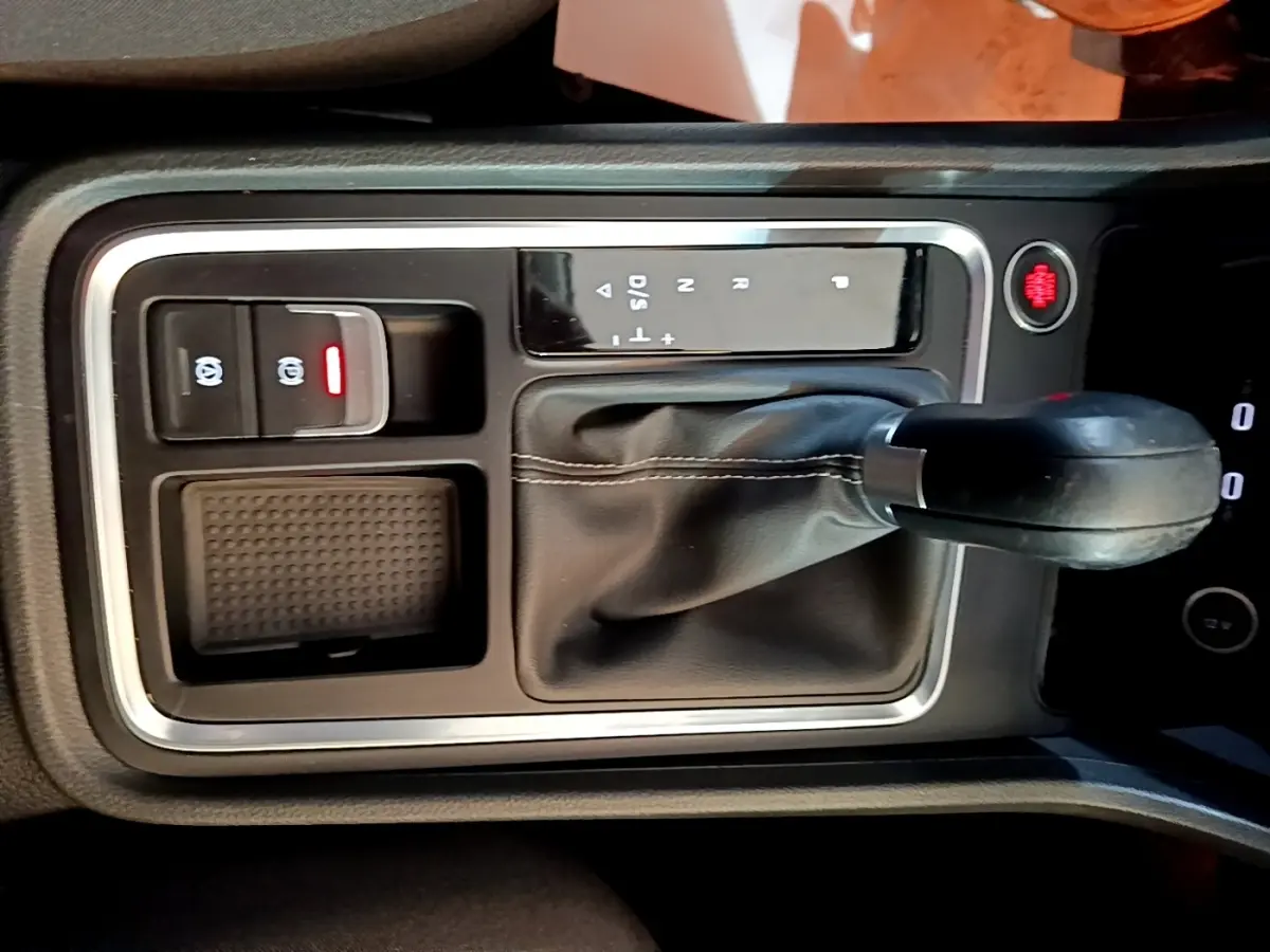 Gros plan sur la console centrale avec levier de vitesse automatique et bouton de frein à main électrique du SEAT Ateca gris clair.
