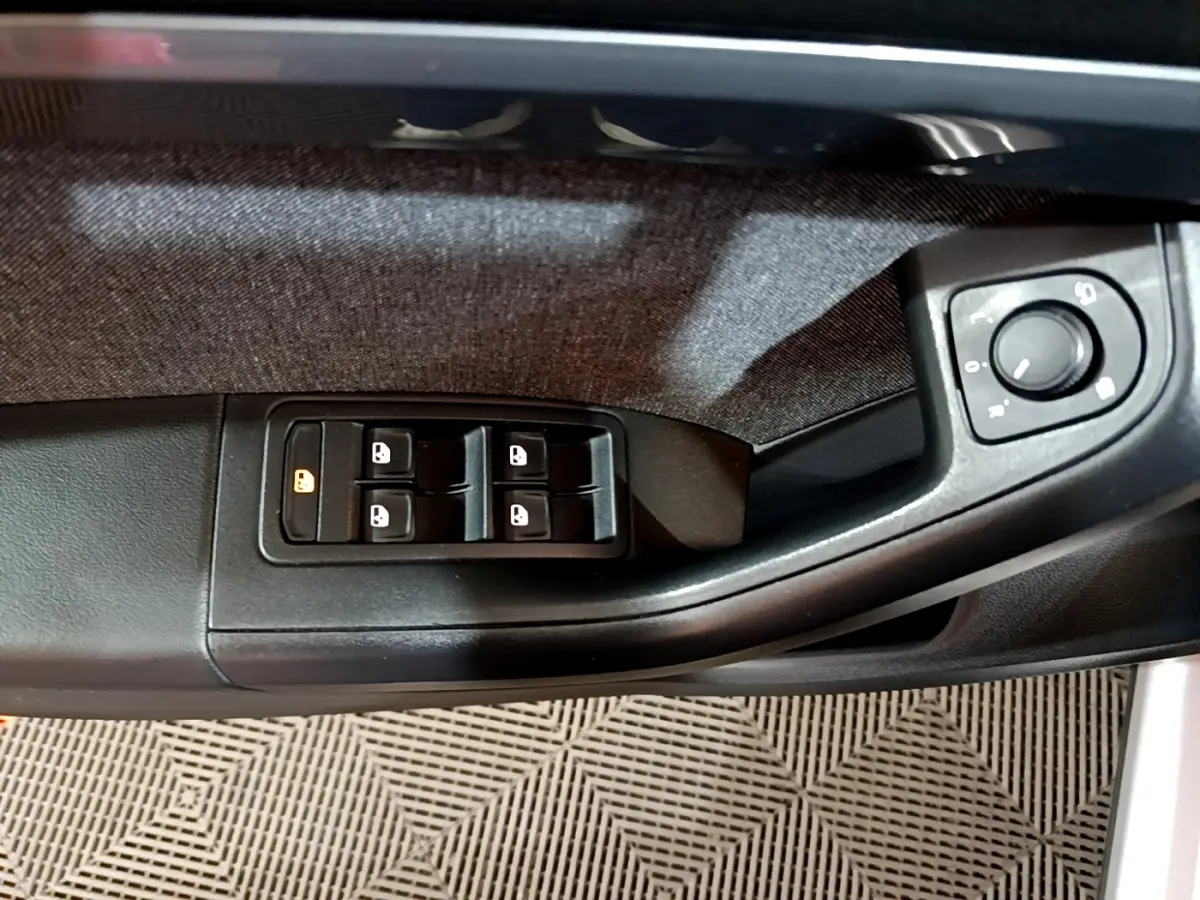 Gros plan sur la commande des vitres et réglage des rétroviseurs côté conducteur du SEAT Ateca gris clair 2022.