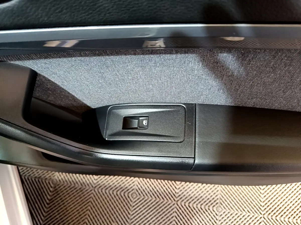 Gros plan sur le bouton de verrouillage des portes côté intérieur d'une SEAT Ateca gris clair.