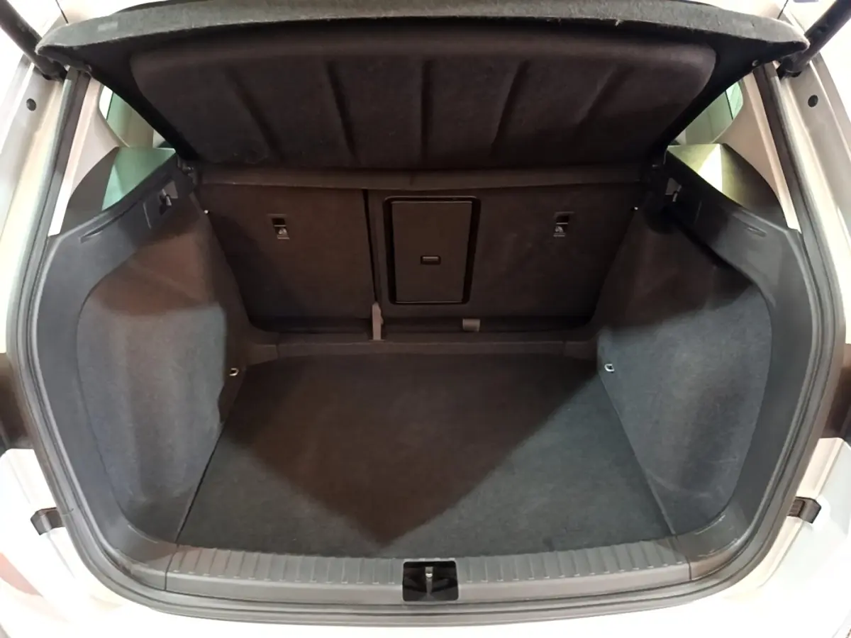 Coffre ouvert vu de l'arrière d'un SEAT Ateca gris clair, espace de chargement vide et revêtement noir.