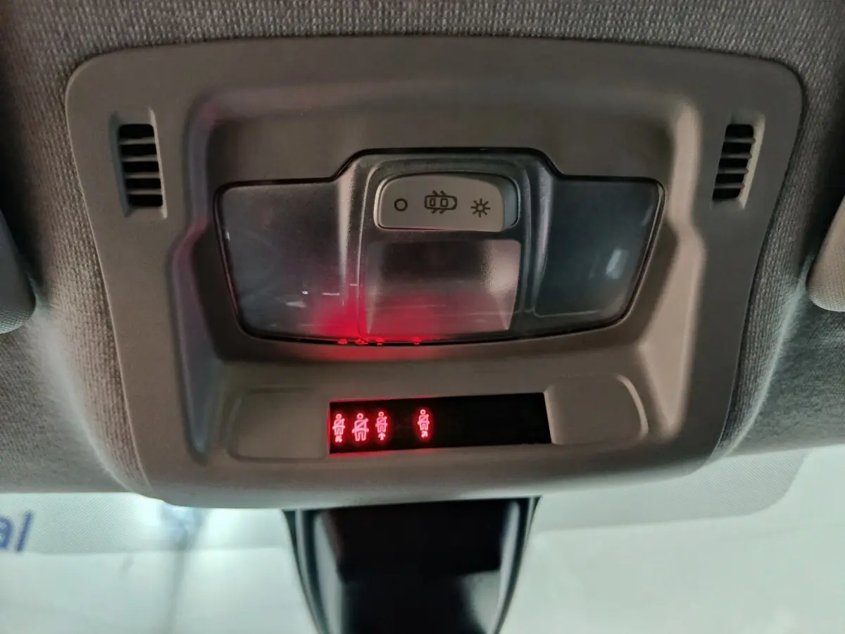 Gros plan sur le plafonnier intérieur gris avec éclairage rouge des ceintures de sécurité dans une Citroën C3 2024.