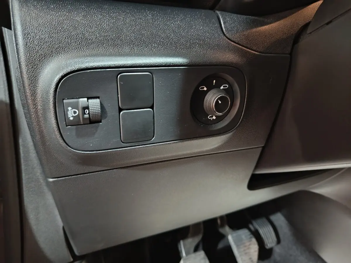 Détail du panneau de commandes côté conducteur de la Citroën C3 gris foncé, avec réglage des phares et des rétroviseurs.
