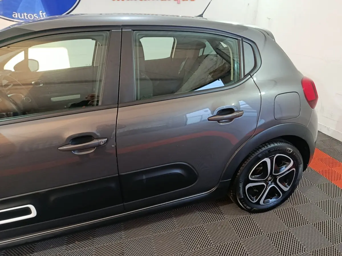 Vue latérale droite d'une Citroën C3 gris foncé 2024, mettant en valeur les jantes noires et les poignées de porte ton caisse.