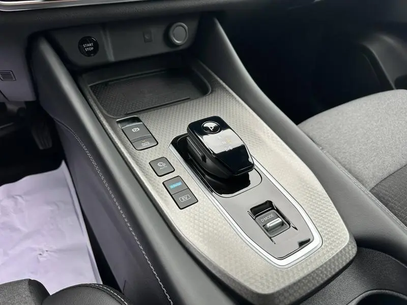 Gros plan sur la console centrale du Nissan Qashqai Hybrid e-POWER 2025, avec levier de vitesses et boutons de commande.