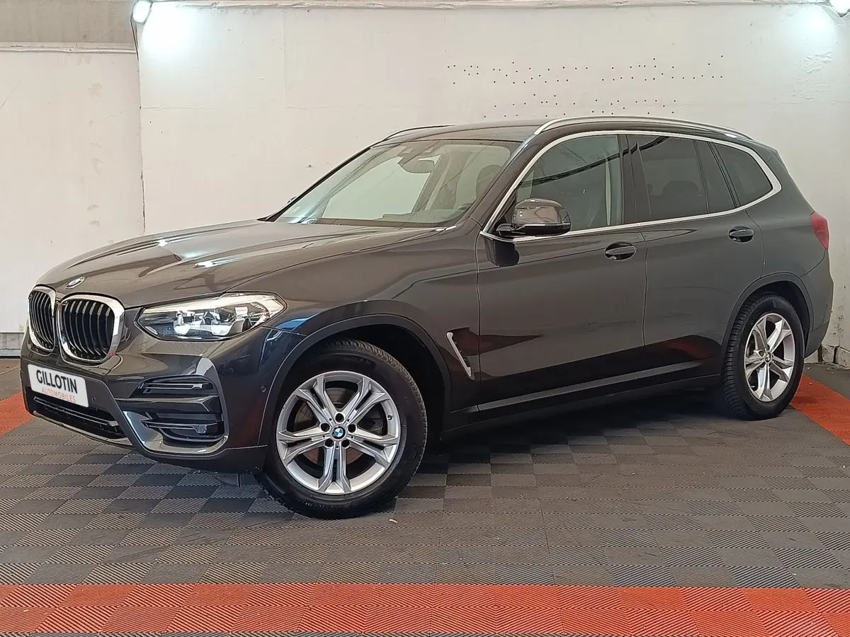 BMW X3 xDrive20d gris clair vu de profil droit en intérieur avec jantes alliage et calandre caractéristique BMW.
