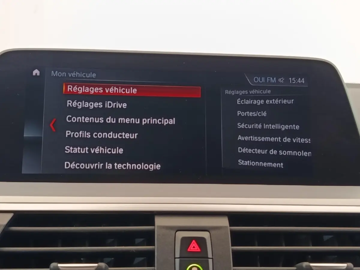 Écran central du tableau de bord d’une BMW X3 gris clair affichant le menu des réglages véhicule.