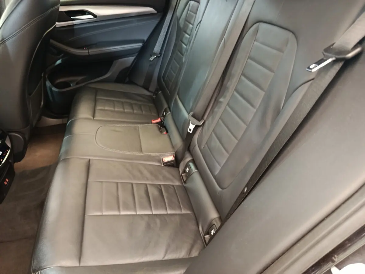 Vue rapprochée de la banquette arrière en cuir noir de la BMW X3 xDrive20d, soulignant les détails des sièges et ceintures.