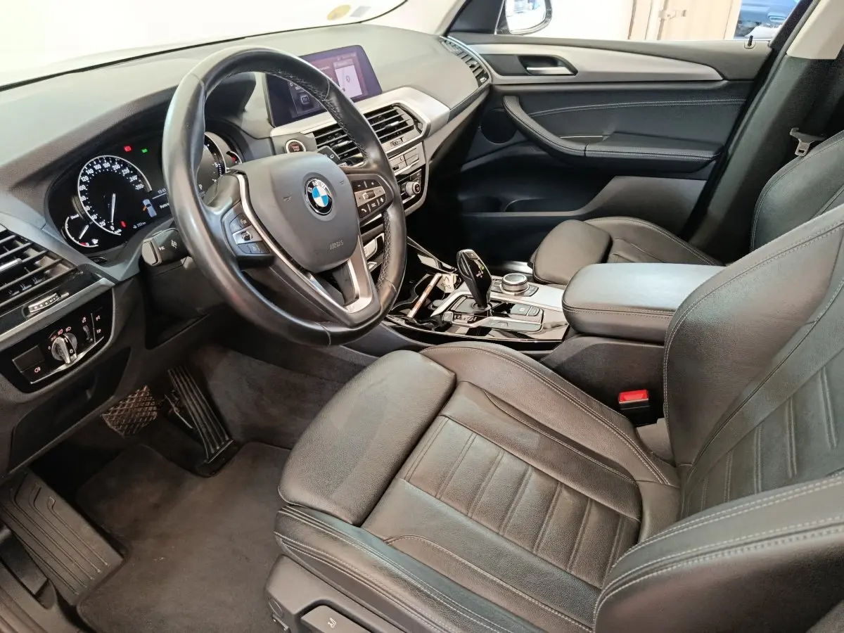 Intérieur BMW X3 xDrive20d 2020 vu côté conducteur, sièges cuir noirs et volant multifonctions alu-cuir.