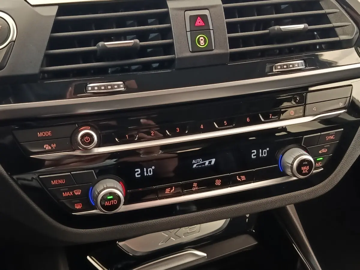 Détail de la console centrale noire du BMW X3 2020 avec commandes climatisation digitale et boutons multifonctions.