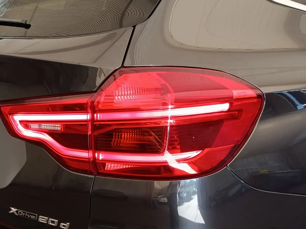 Gros plan sur le feu arrière droit rouge d’un BMW X3 gris clair xDrive20d 2020 avec logo visible.