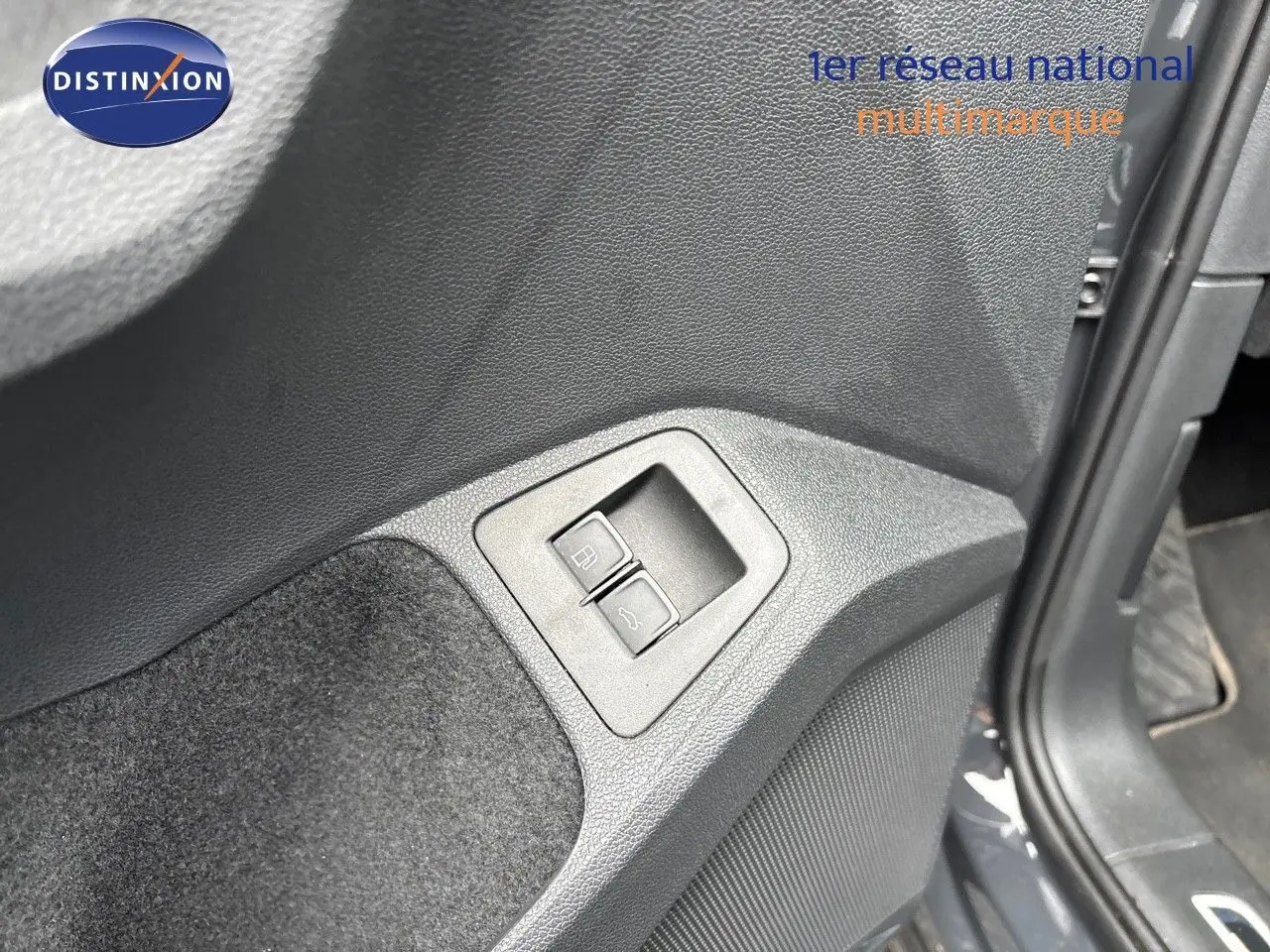 Boutons d'ouverture du coffre et de la trappe à carburant sur le panneau intérieur côté gauche d'un Volkswagen Tiguan gris lunaire 2022.