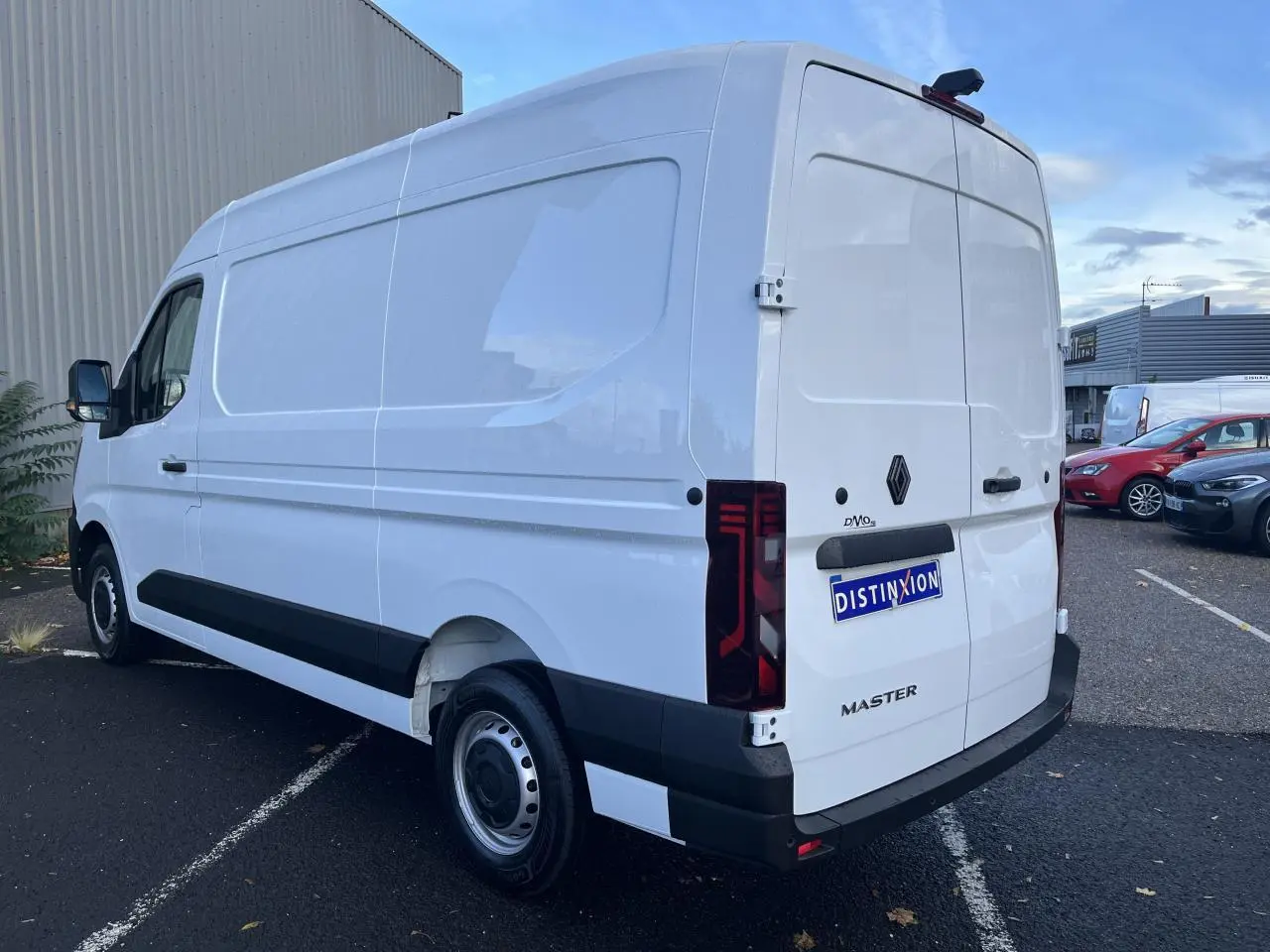 Renault Master blanc en vue 3/4 arrière droit, fourgon tôlé avec feux arrière verticaux et jantes tôle.