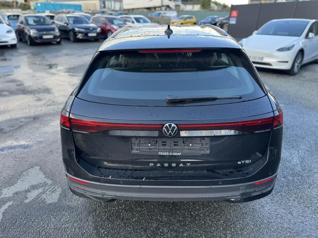 Vue arrière d'une Volkswagen Passat SW noire 2024 avec feux arrière LED et logo VW centré sur le hayon.