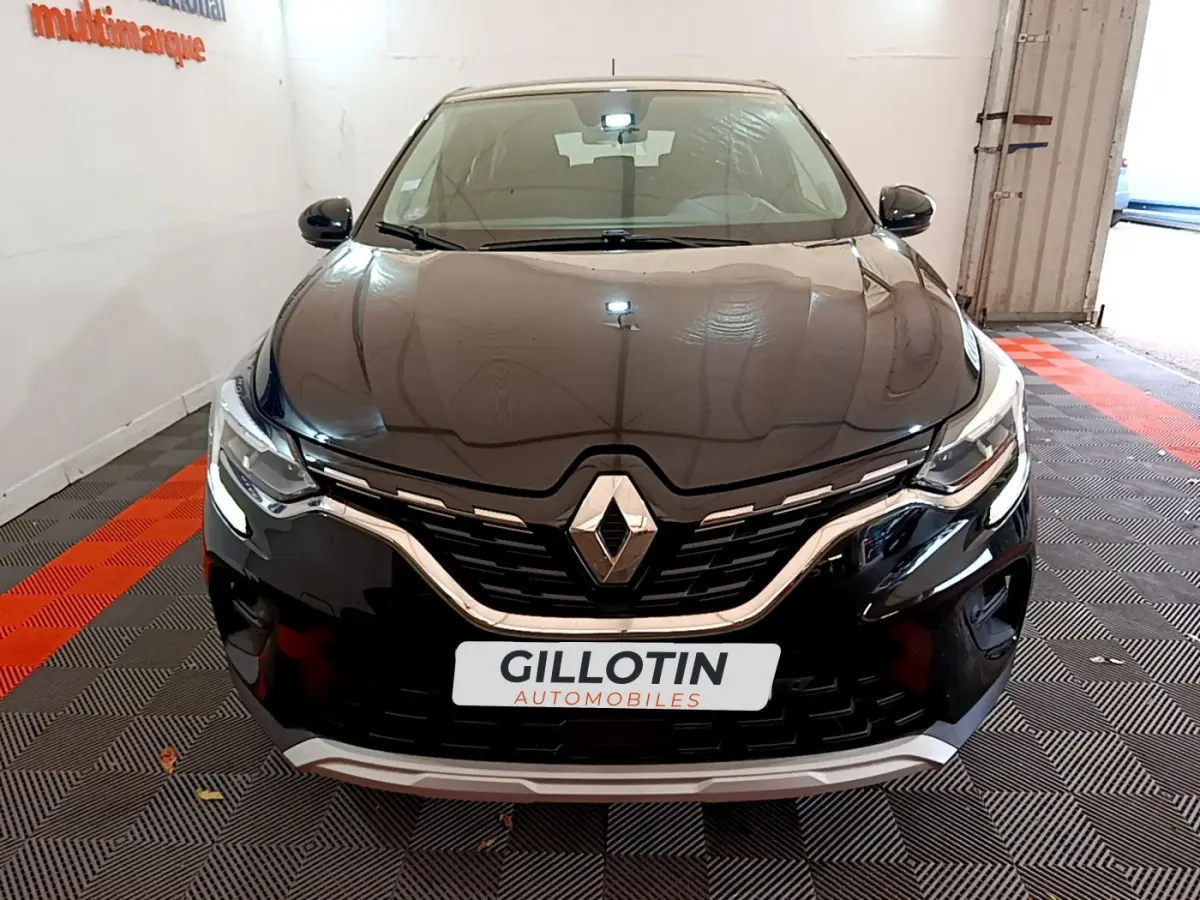 Vue de face du Renault Captur Business TCe 90 noir, mettant en valeur sa calandre chromée et ses phares LED allumés.
