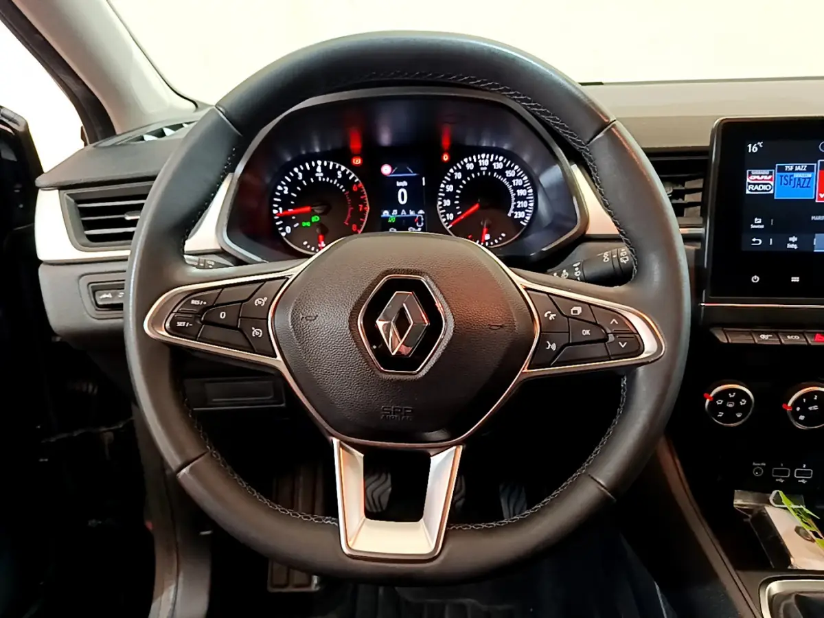 Vue rapprochée du volant noir de la Renault Captur Business 2021 avec tableau de bord et écran tactile visible à droite.