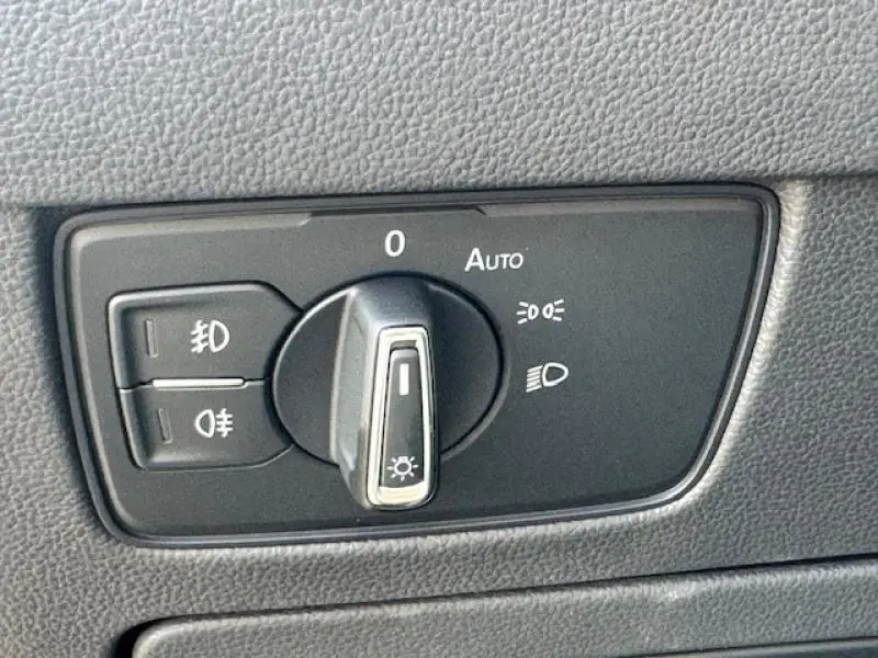 Gros plan sur le sélecteur de feux noir dans l'habitacle de la Volkswagen Passat SW gris manganèse métallisé 2022.