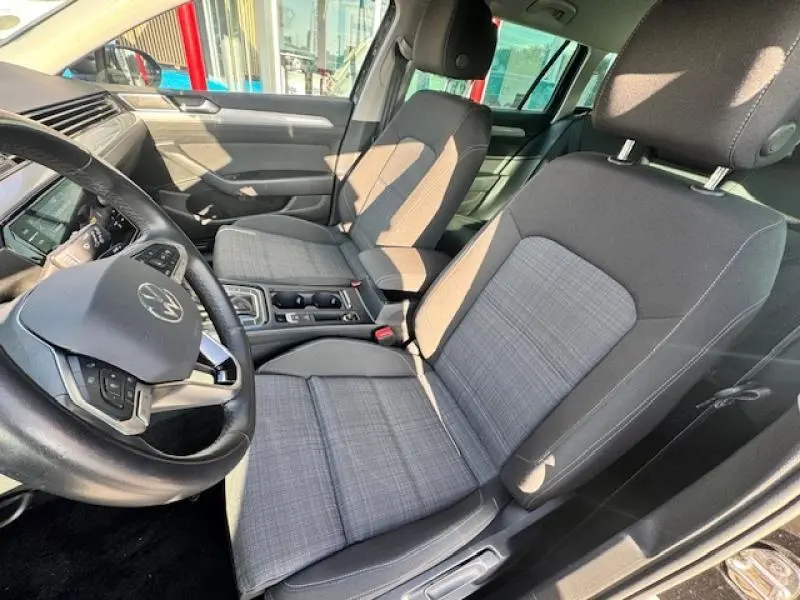 Intérieur avant de la Volkswagen Passat SW 2022, sièges tissu gris Weave et volant cuir multifonction visible côté conducteur.