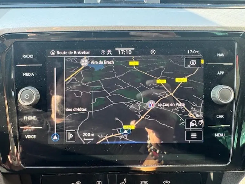 Vue rapprochée de l'écran tactile du GPS dans une Volkswagen Passat SW gris manganèse, affichant une carte routière.