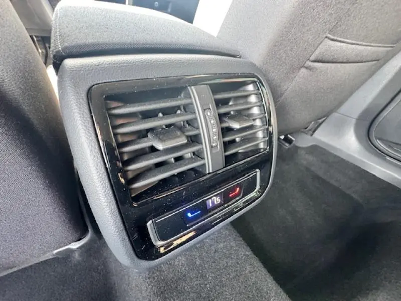 Gros plan sur la sortie d'air arrière avec réglage de température dans l'habitacle gris d'une Volkswagen Passat SW 2022.