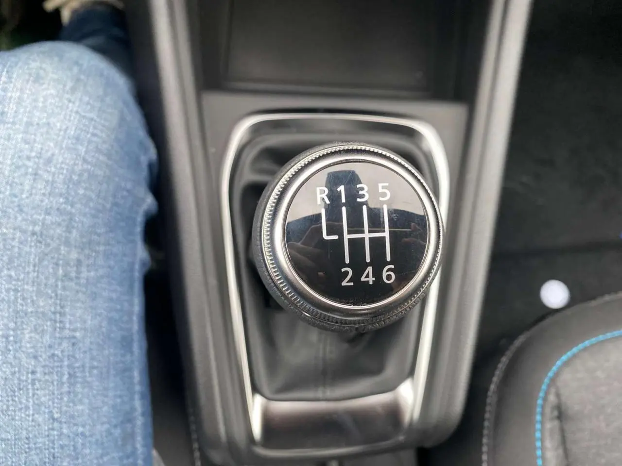 Gros plan sur le levier de vitesses manuel noir du Renault Captur 2025, avec couture bleue visible sur le siège à droite.