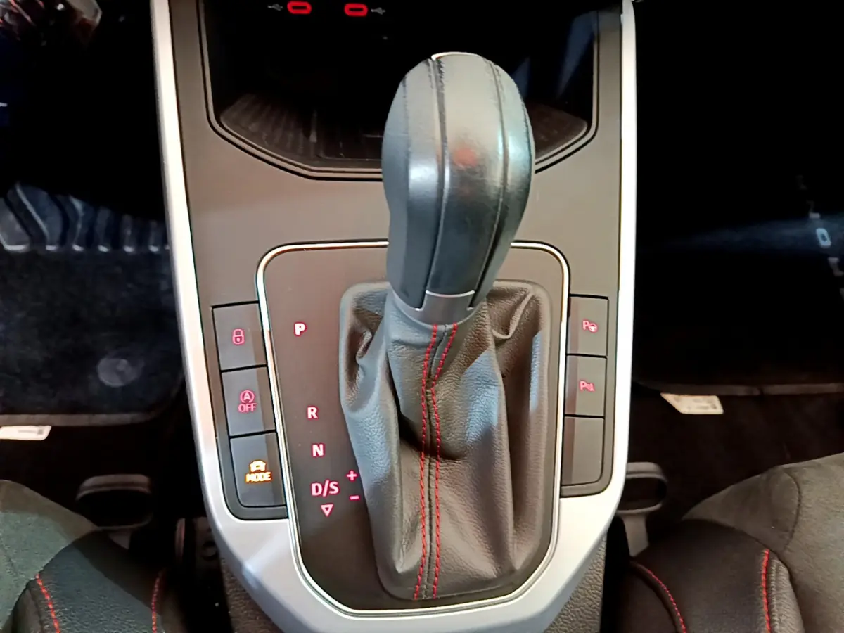 Le levier de vitesses automatique noir avec surpiqûres rouges du SEAT Arona 2022, vue de dessus intérieure.