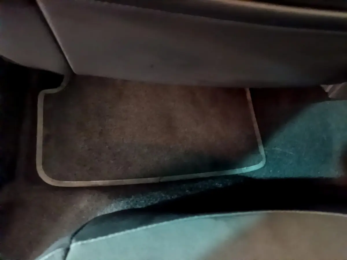 Vue rapprochée du tapis de sol marron sous le siège passager arrière d’un SEAT Arona bleu 2022.