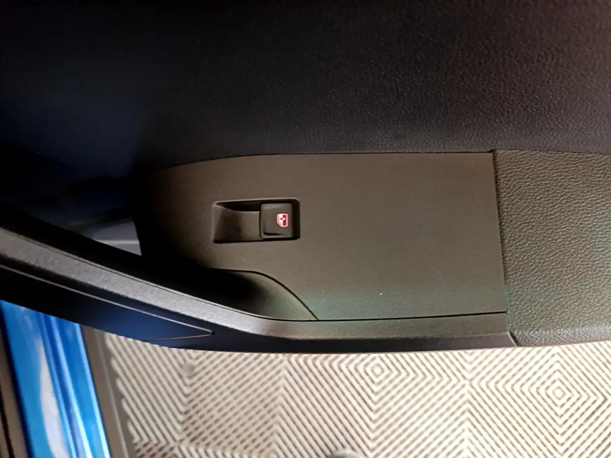 Bouton de verrouillage des portes sur la portière côté conducteur d'un SEAT Arona bleu 2022, vue rapprochée.