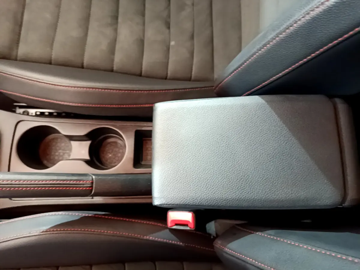 Vue plongeante sur la console centrale noire avec accoudoir et porte-gobelets du SEAT Arona 2022 finition FR.