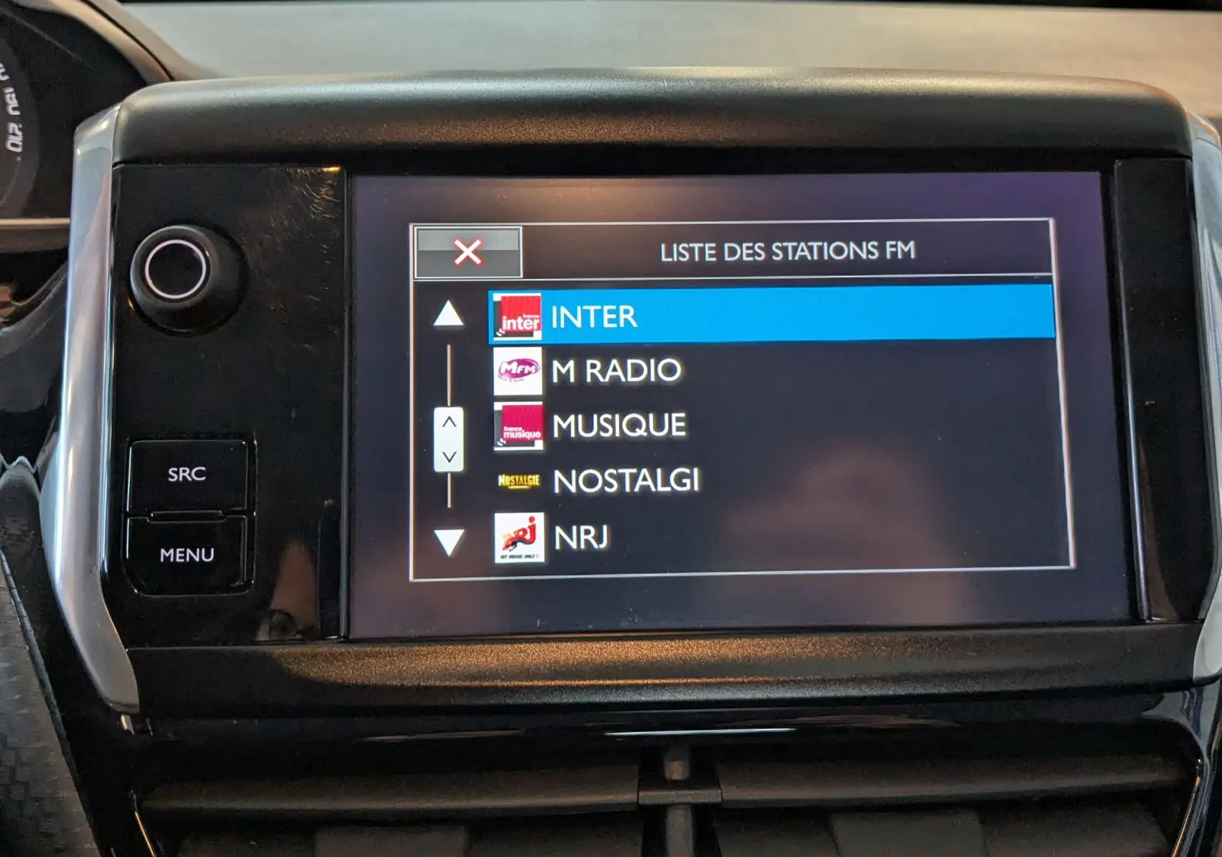 Écran tactile central du Peugeot 2008 blanc de 2017 affichant la liste des stations FM avec sélection sur France Inter.