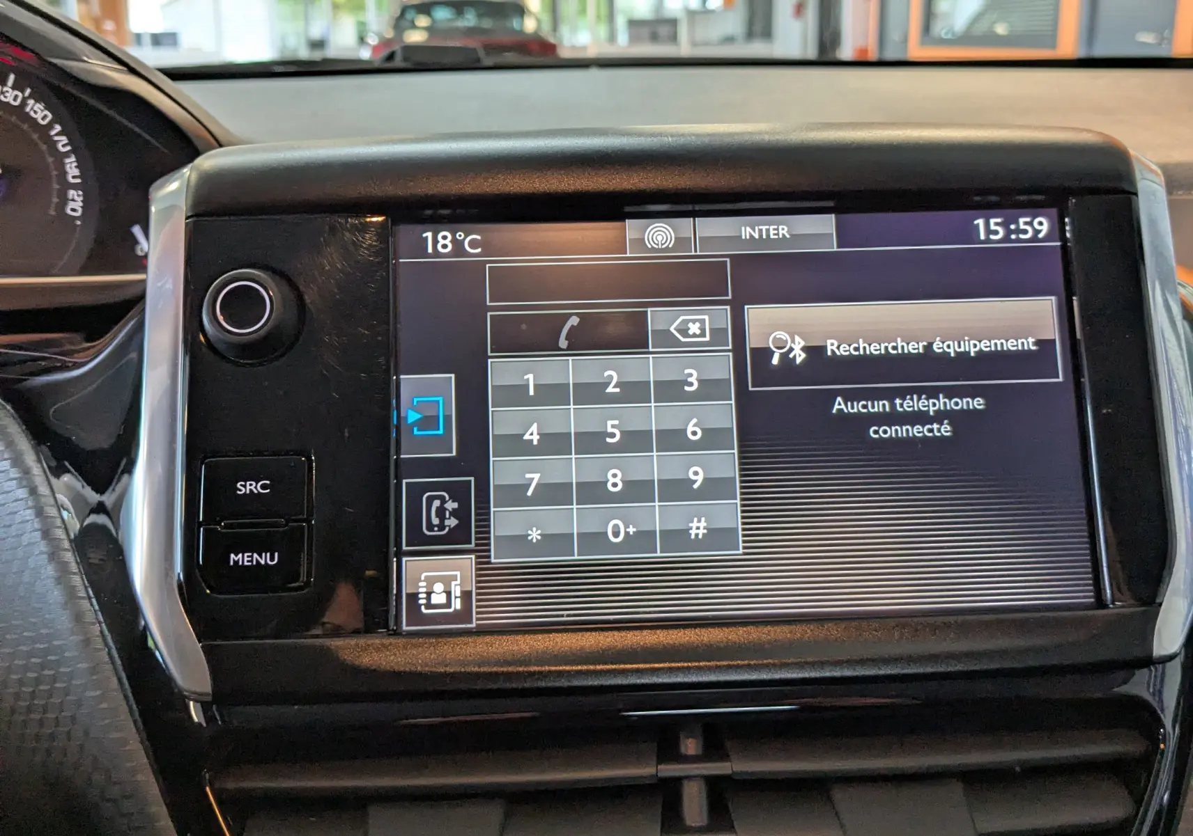 Vue rapprochée de l'écran tactile central du tableau de bord du Peugeot 2008 blanc, affichant le menu téléphone.