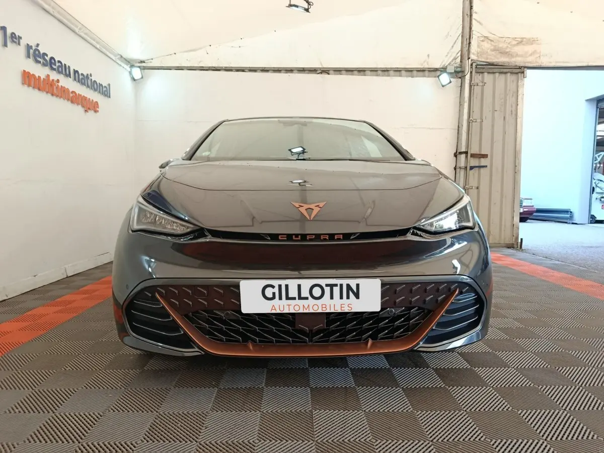 Vue frontale d'une CUPRA BORN gris foncé avec détails cuivrés et logo distinctif sur calandre.