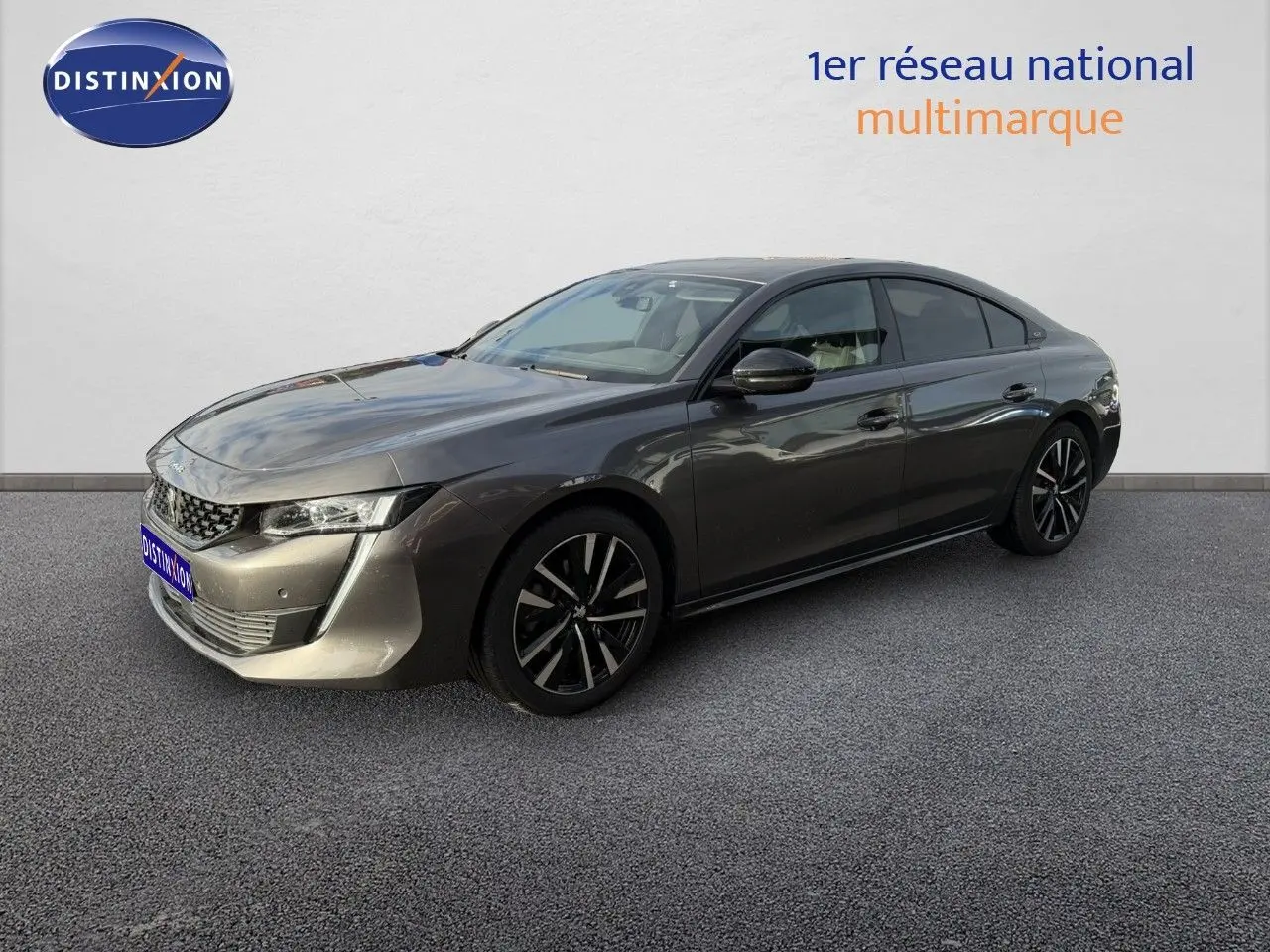 Peugeot 508 gris platinium en 3/4 avant droit, mettant en valeur ses lignes élégantes et ses jantes noires.