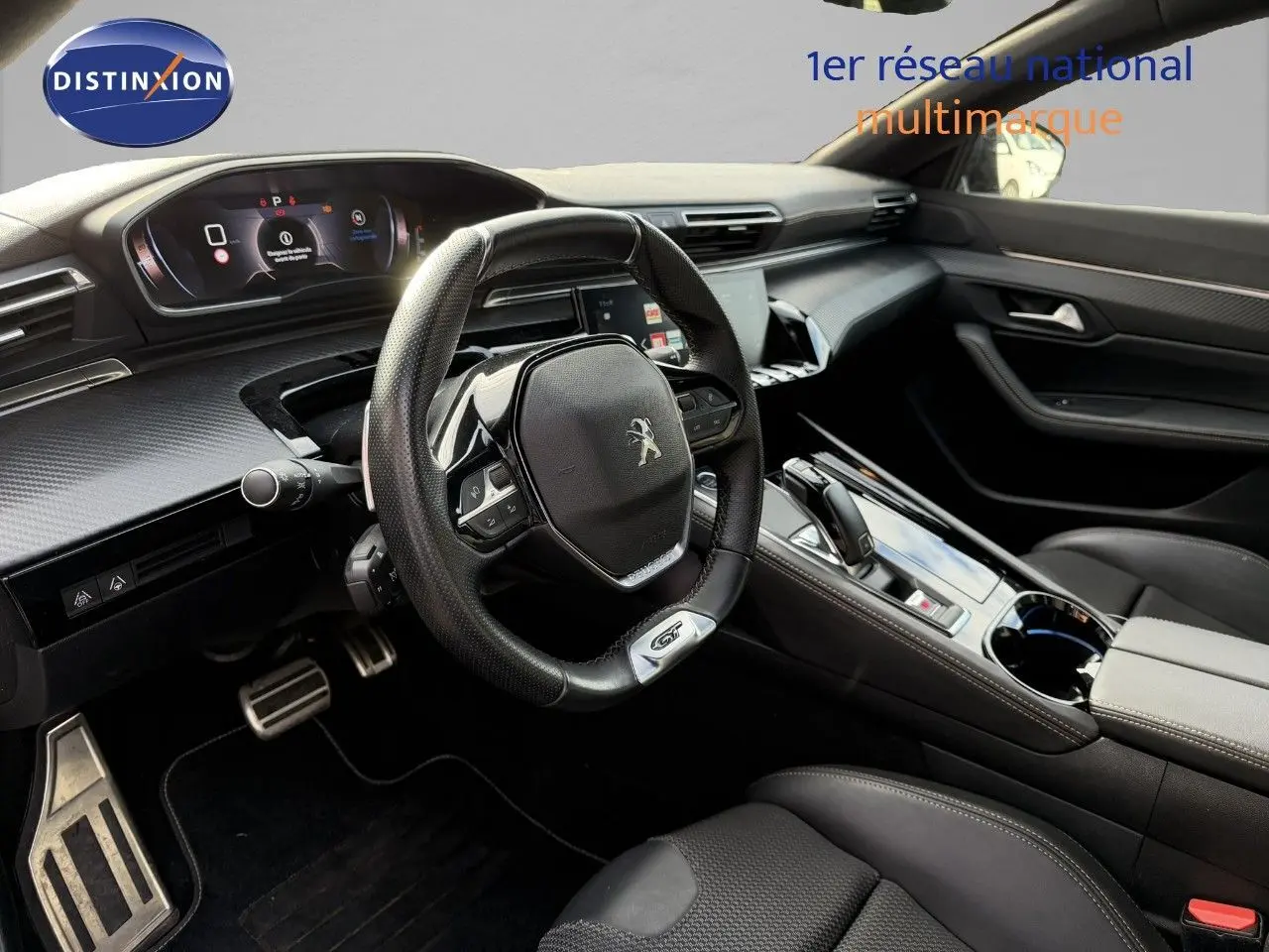 Intérieur côté conducteur du Peugeot 508 gris platinium 2023, tableau de bord moderne et volant sport GT en cuir noir.