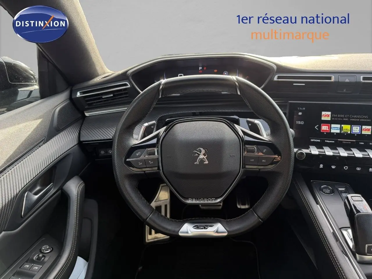 Vue intérieure centrée sur le volant GT de la Peugeot 508 gris platinium avec tableau de bord numérique et console moderne.