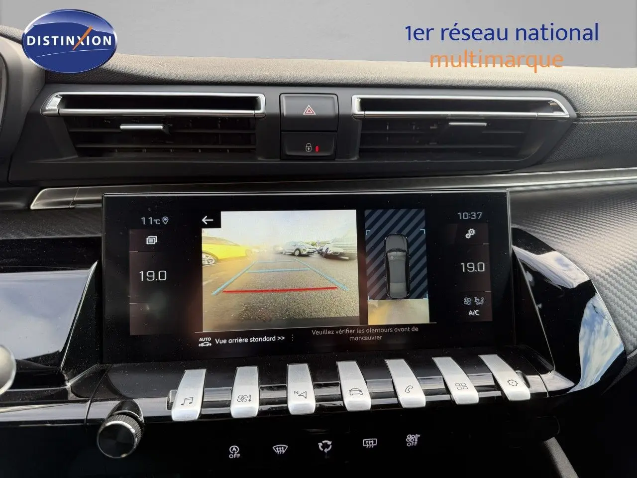 Vue rapprochée de l'écran central tactile du Peugeot 508 gris platinium, affichant la caméra de recul et la climatisation à 19°C.