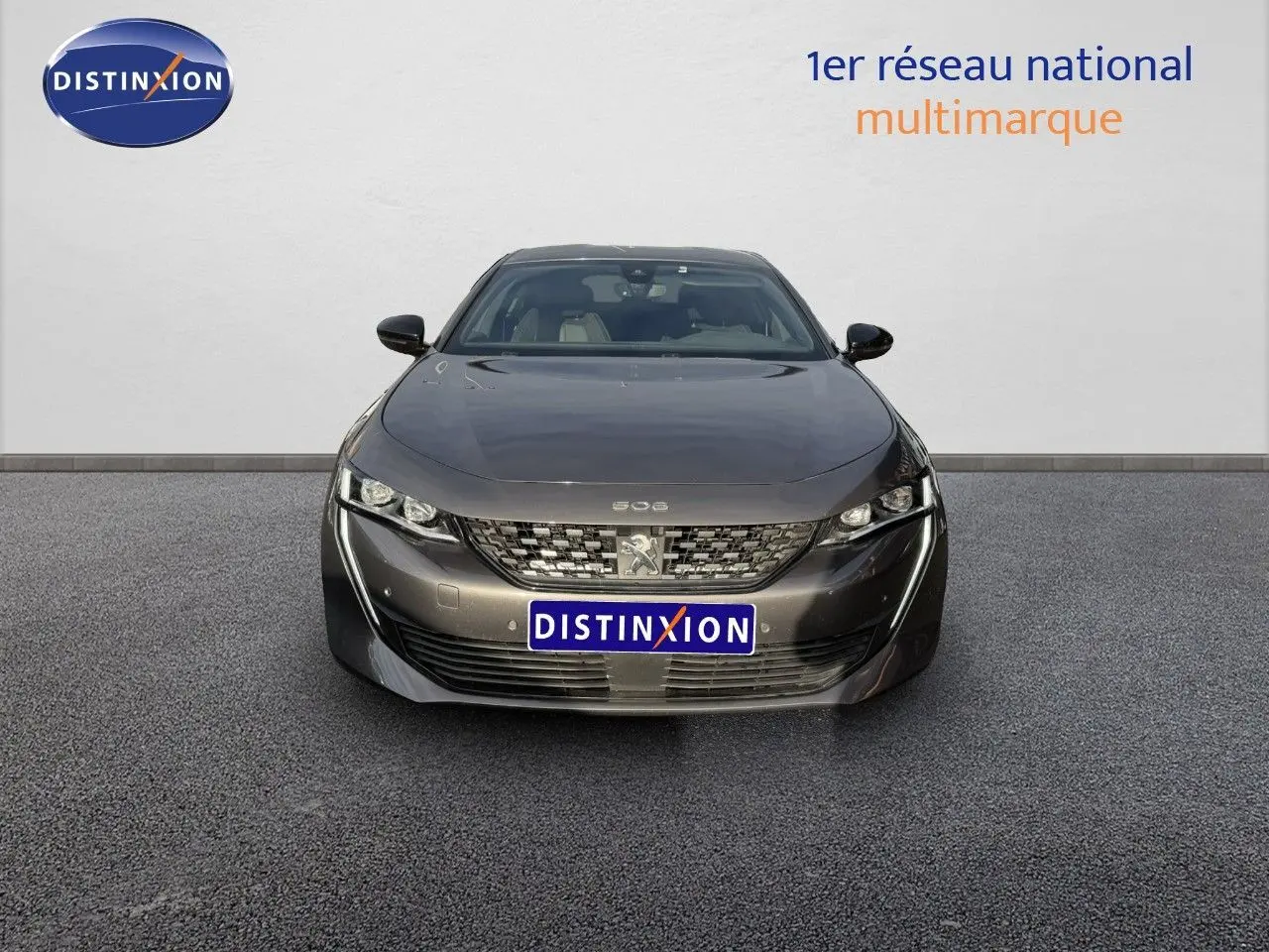 Vue frontale d'une Peugeot 508 gris platinium 2023 avec calandre distinctive et phares LED fins.
