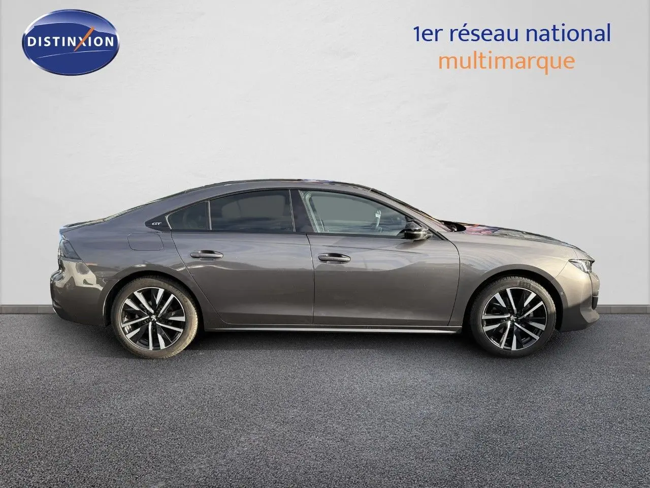 Profil droit d'une Peugeot 508 II GT gris platinium de 2023, soulignant ses jantes alliage et lignes élégantes.