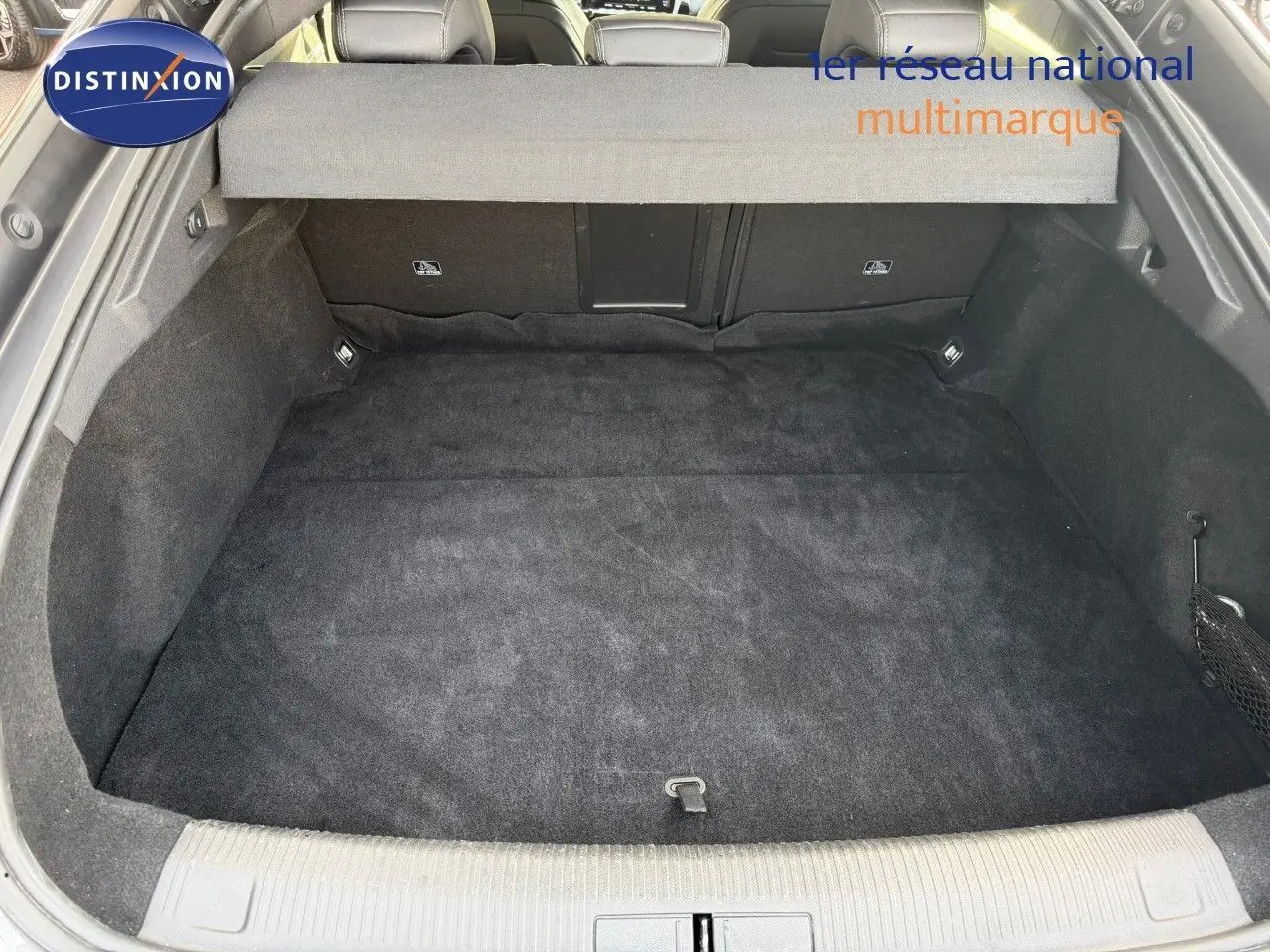 Coffre spacieux et propre de Peugeot 508 gris platinium, vue depuis l'arrière avec cache-bagages déployé.