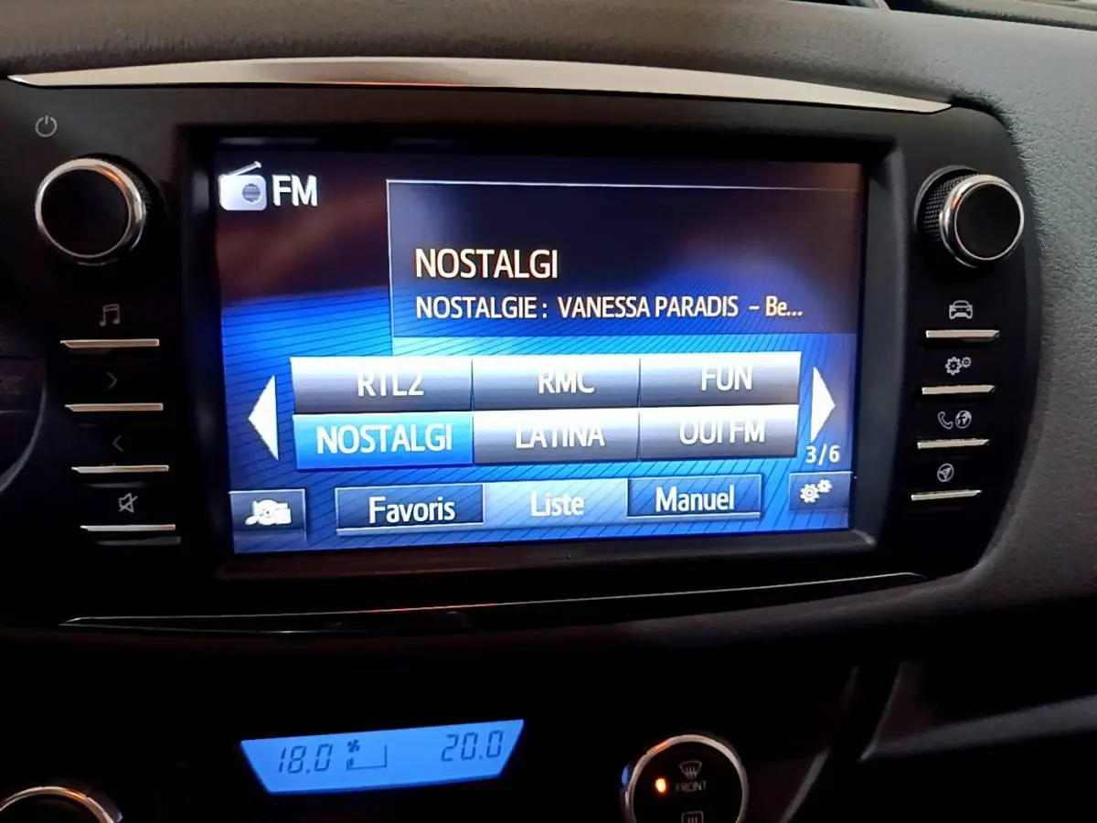 Écran tactile central de la Toyota Yaris 1.5 Hybride 2020 affichant la radio FM avec menu de stations et commandes latérales.
