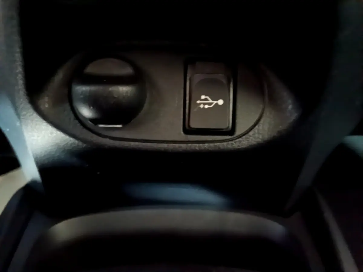 Gros plan sur la prise 12V et le port USB dans l’habitacle de la Toyota Yaris blanche 1.5 Hybride 2020.