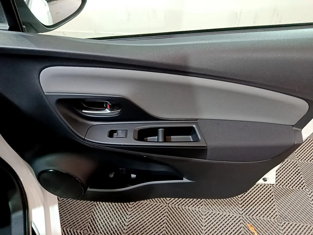 Vue rapprochée de la porte avant gauche intérieure noire et grise de la Toyota Yaris blanche 2020 hybride.