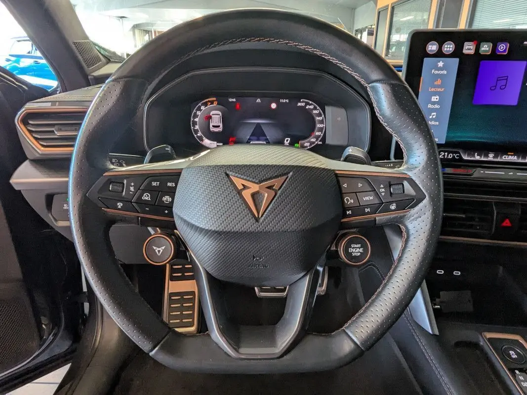Vue rapprochée du volant noir perforé de la CUPRA Formentor 2.0 TDI 150 DSG7 avec commandes intégrées et tableau de bord numérique.